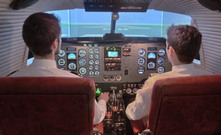 Alumnos de la escuela de pilotos durante una sesión de instrucción en simulador del curso piloto comercial 
